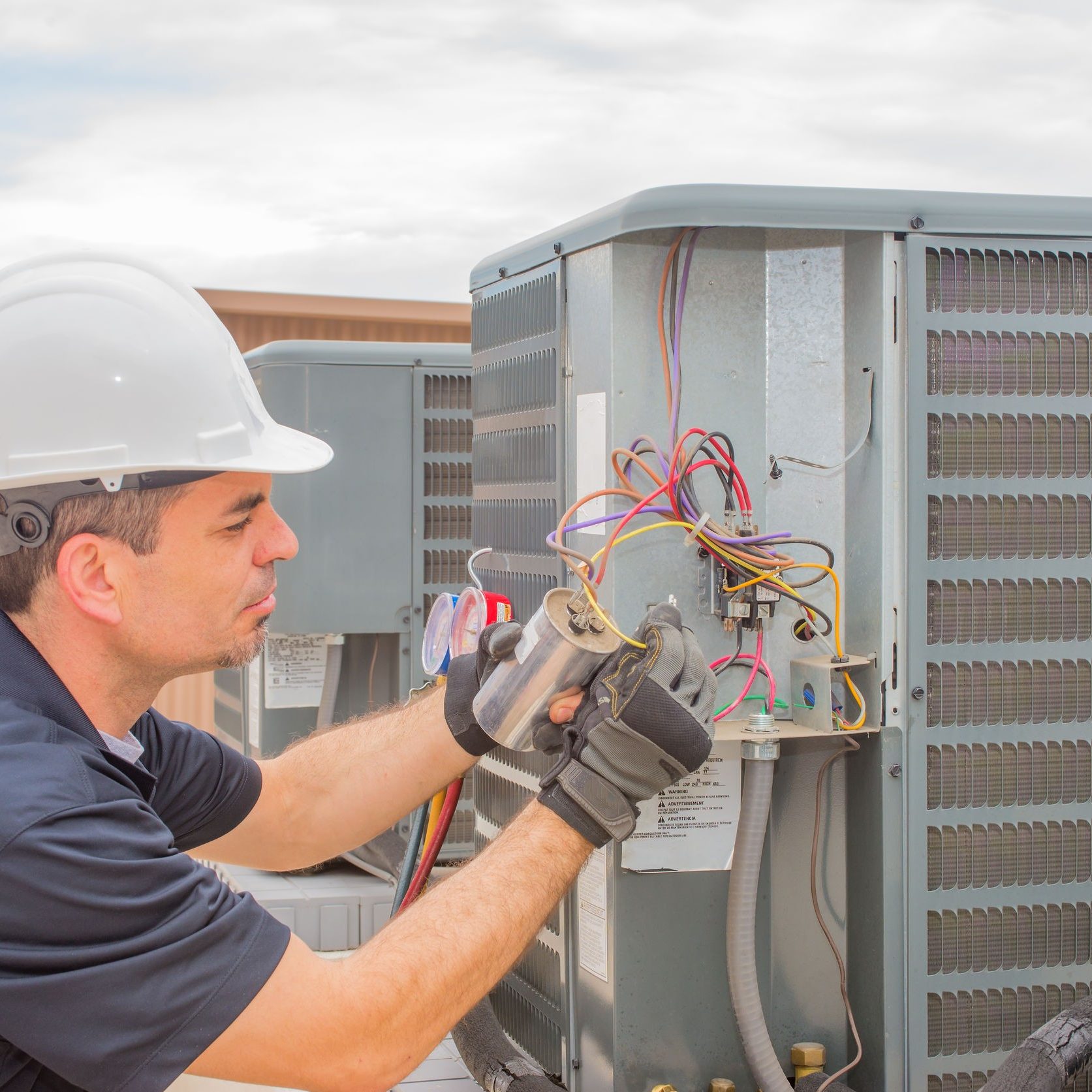 85556380 - hvac technician checking capacitor on air conditioner Service Emperor hvac technician checking capacitor on air conditioner